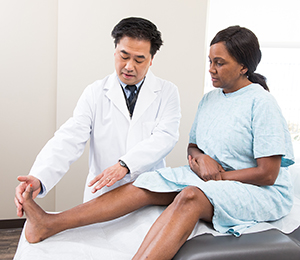 Un professionnel de la santé examinant le pied d'une femme.